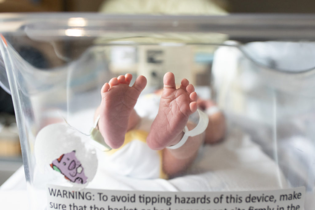 newborn feet in bassinet