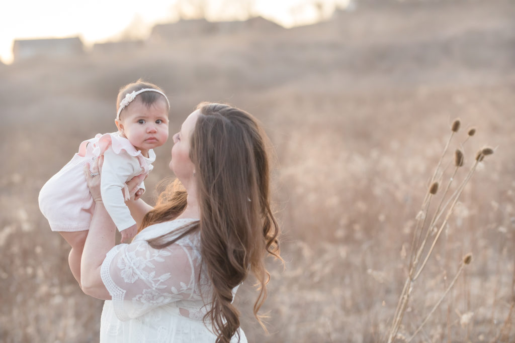 Sweet baby girl being held by Mom during portrait session